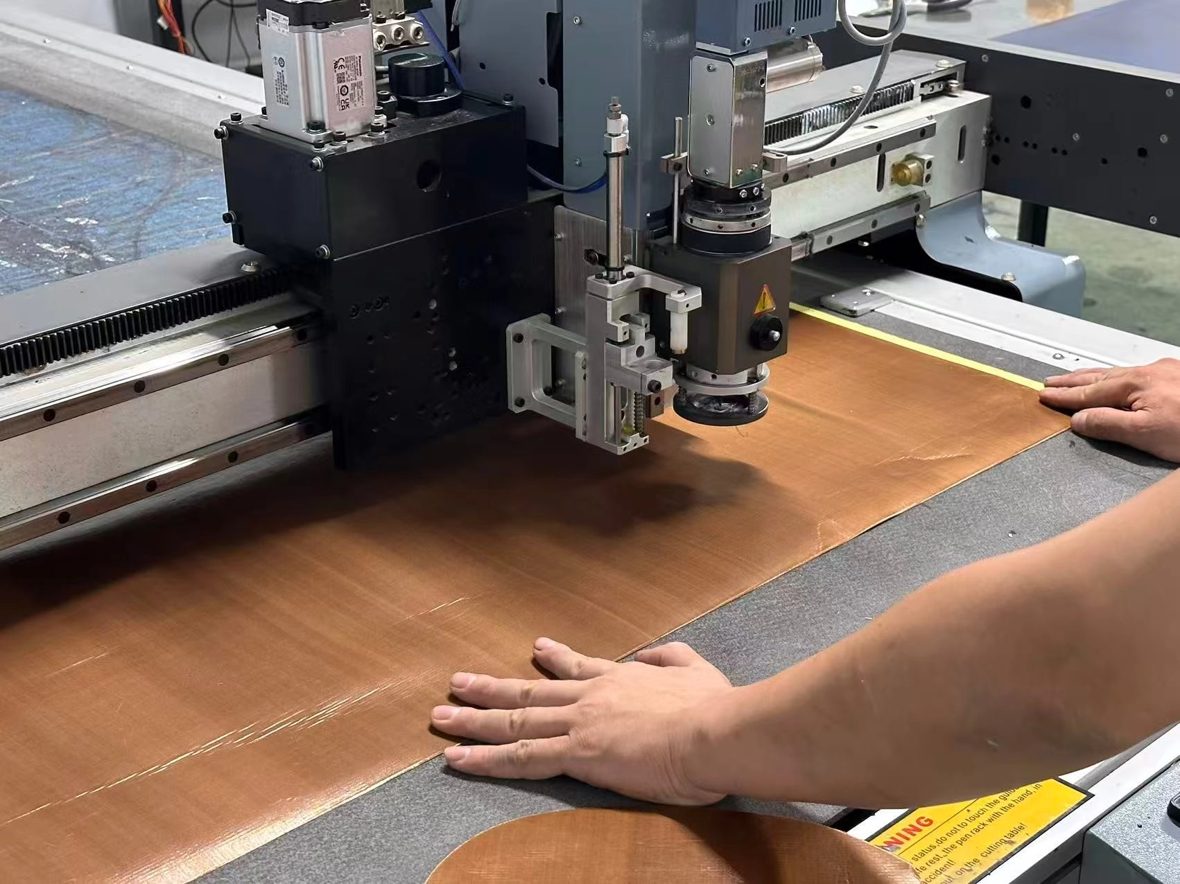 Precision cutting of composite material for helmet shell production